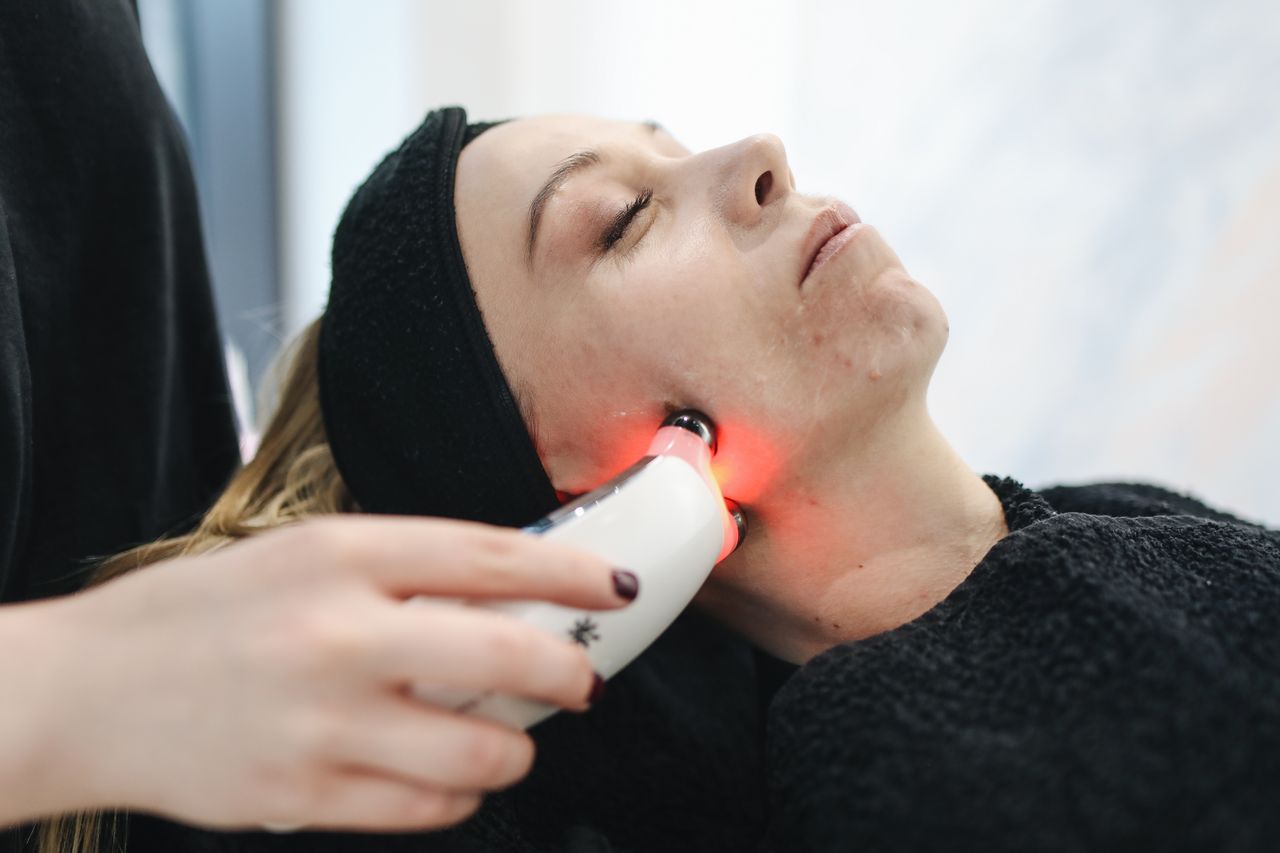 about-01 An adult woman receives a laser facial treatment in a modern skincare clinic.